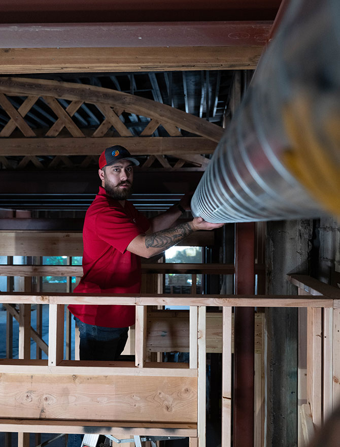 DUCT-REPAIR-2-670×880 Man holding up ductwork